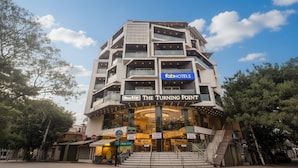 A multi-story hotel with a modern design, featuring balconies and a prominent sign for 'fabHOTELS'. - Fabhotel Turning Point (Bengaluru)