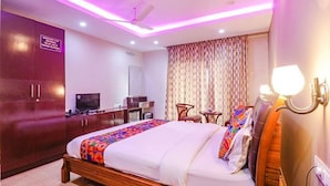 A hotel room with a bed, a desk, a television, and a wardrobe. - Fabhotel Turning Point (Bengaluru)
