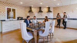 A modern kitchen with a checkered backsplash, white cabinets, and a marble countertop. - Fabhotel Turning Point (Bengaluru)