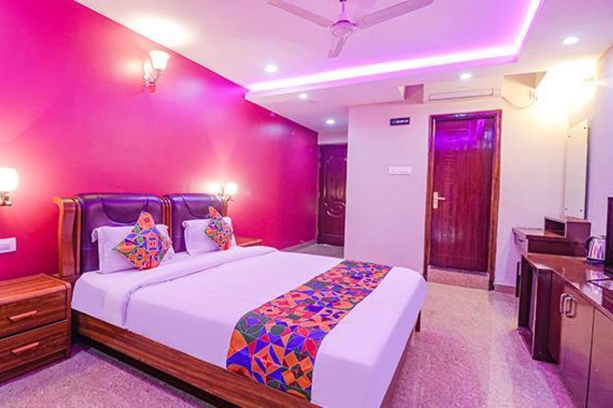 A bedroom with a bed, bedside tables, a wardrobe, and a door.