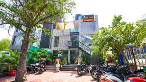 A hotel with a modern design, featuring a staircase leading to the entrance, and several motorcycles parked in front. - Fabexpress Golden Stone (Ghaziabad)