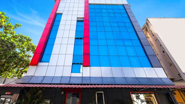 A tall building with a facade featuring a mix of white, blue, and red panels, and a 'fabexpress' sign at the top. - Fabexpress India Gate (Chennai)