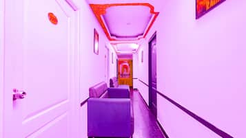 A hallway with a reception area, a sign reading "INDIA GATE," and a door with a security camera.