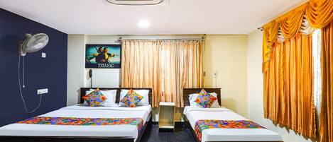 A hotel room with two beds, a ceiling fan, a wall-mounted air conditioner, and a window with curtains.