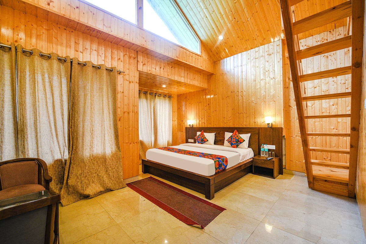 A wooden cabin bedroom with a bed, nightstand, and a chair.