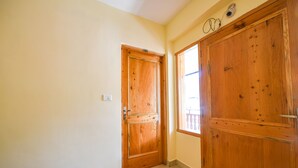 Corredor com portas de madeira e uma janela.