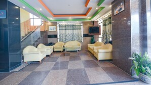 A lobby with a checkered floor, two sofas, a television, and a staircase. - Fabhotel Prime The Kalinga Grand (Manali)