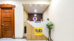 Un comptoir d’accueil avec une porte en bois et une enseigne indiquant « fab hotels ».