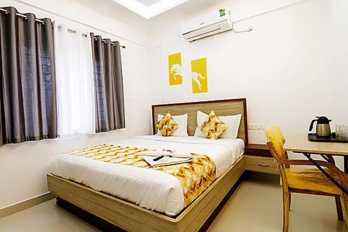 A hotel room with a bed, a desk, and a chair.