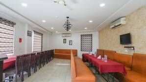 A conference room with a long table, chairs, and a sofa. - Fabhotel Shriansh (Agra)