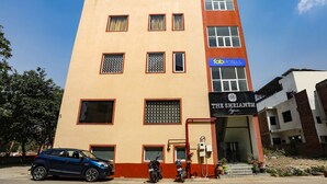 A multi-story building with a flat facade, a sign for 'The Shriansh' hotel, and a parked car. - Fabhotel Shriansh (Agra)