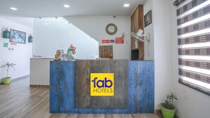 A reception desk with a 'fab hotels' logo, a clock, and a sign prohibiting outside food and drink. - Fabhotel Shriansh (Agra)