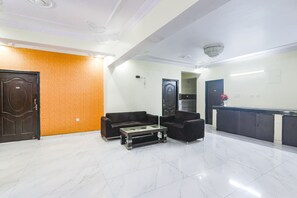 A lobby with a reception desk, two sofas, a coffee table, and a door. - Fabhotel Yamini Inn (Patna)