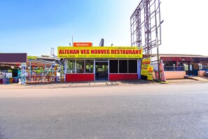 A restaurant named Alishan Veg Nonveg with a signboard advertising Halal Food, Indian, Chinese, Moghlai, Tandoor, and Sea Food.