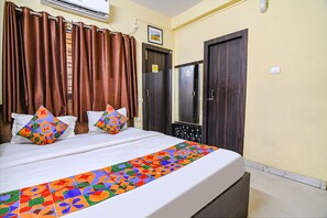 A hotel room with a bed, curtains, a mirror, and a door. - Fabhotel Eco Inn (Barasat)
