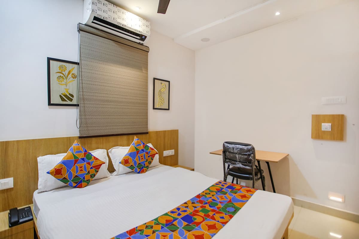 A hotel room with a bed, a desk, and a chair.