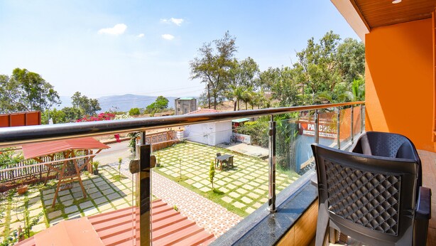 A balcony with a view of a garden, a wooden pergola, and a checkered floor. - Fabexpress Prajakta Holiday Inn (Mahabaleshwar)