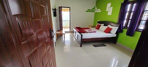 Ein Schlafzimmer mit einem Bett, einer Holztür und einer grünen Wand.