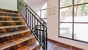 A staircase with marble steps and a metal railing. - Fabhotel Pacific Inn (Dehradun)
