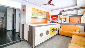 A reception area with a counter, a sofa, and a ceiling fan.