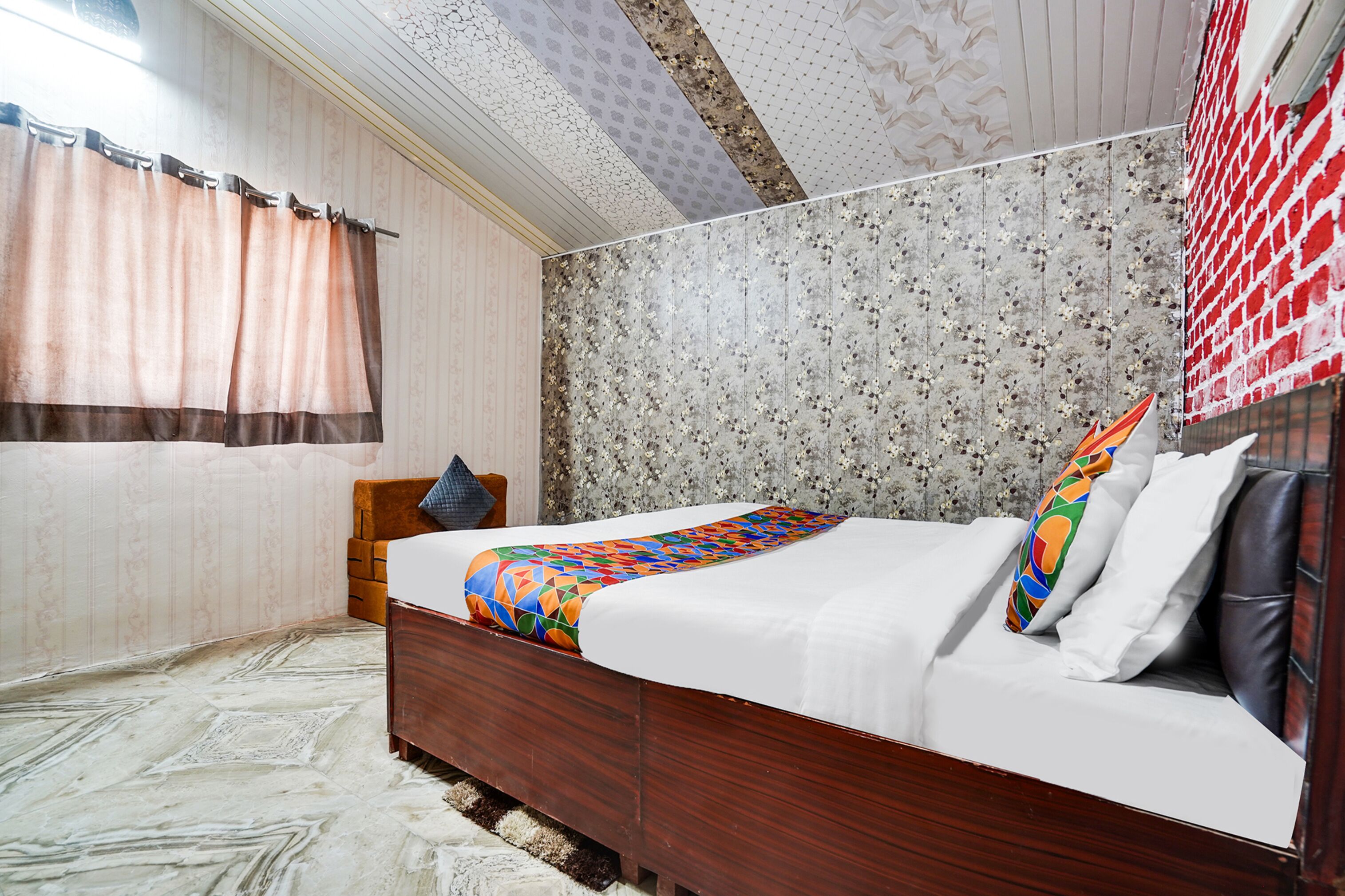 Un dormitorio con una cama de madera, un cabecero estampado y una ventana con cortinas.