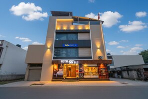Un hôtel moderne, reconnaissable à son enseigne bien visible « fabHOTELS » et à l’entrée marquée « HOTEL SS BLU ».