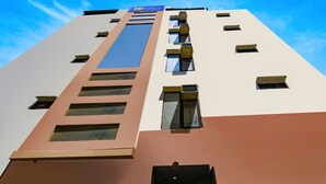 A tall building with a 'Tab Hotels' sign, multiple windows, and a central vertical strip. - FabHotel PP Residency Tilak Nagar (New Delhi)