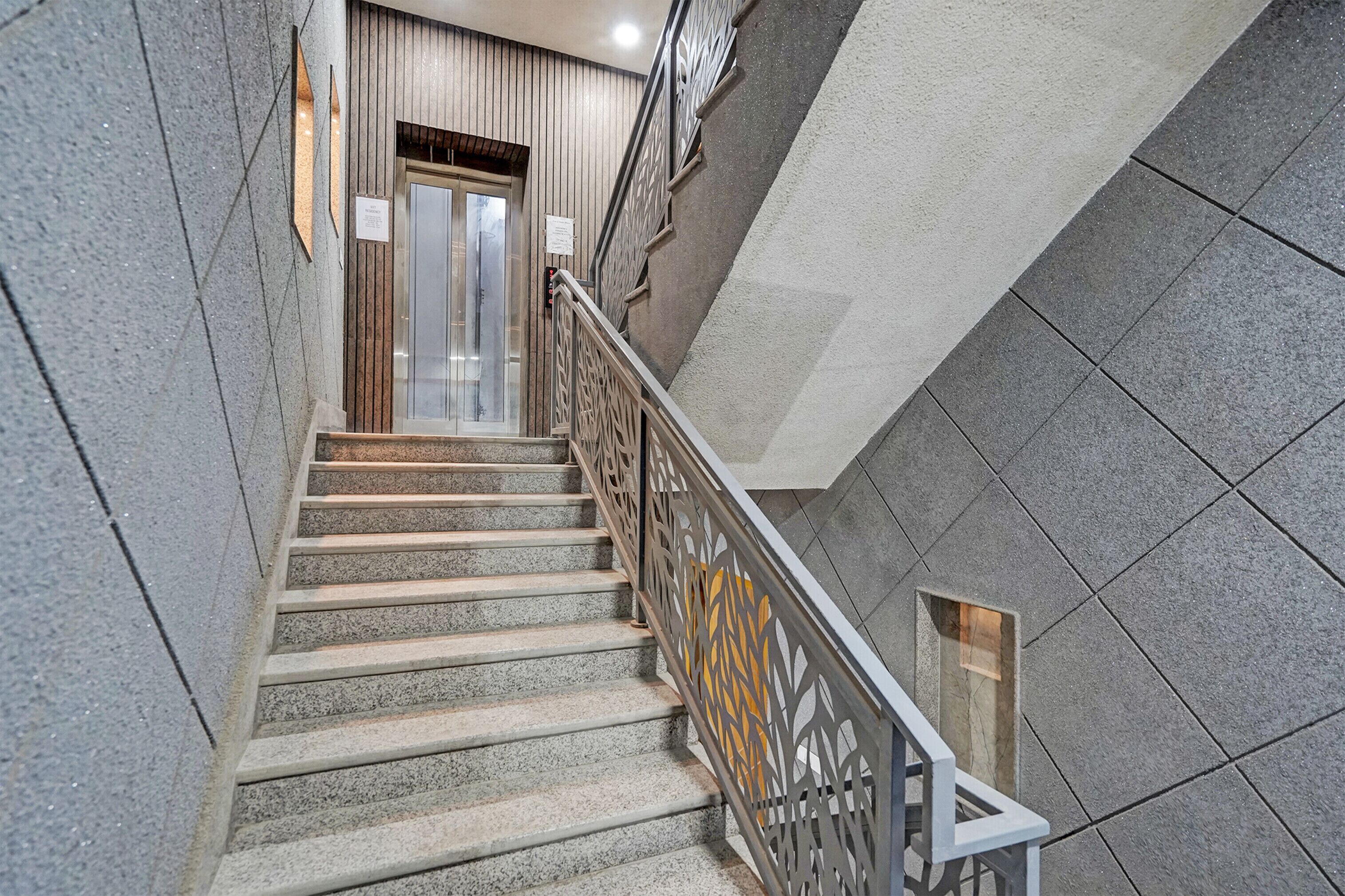 A staircase with a metal railing and a wooden door at the top.