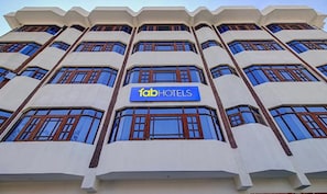 Un edificio de varios pisos con un letrero que dice "fabHOTELS" en la fachada.