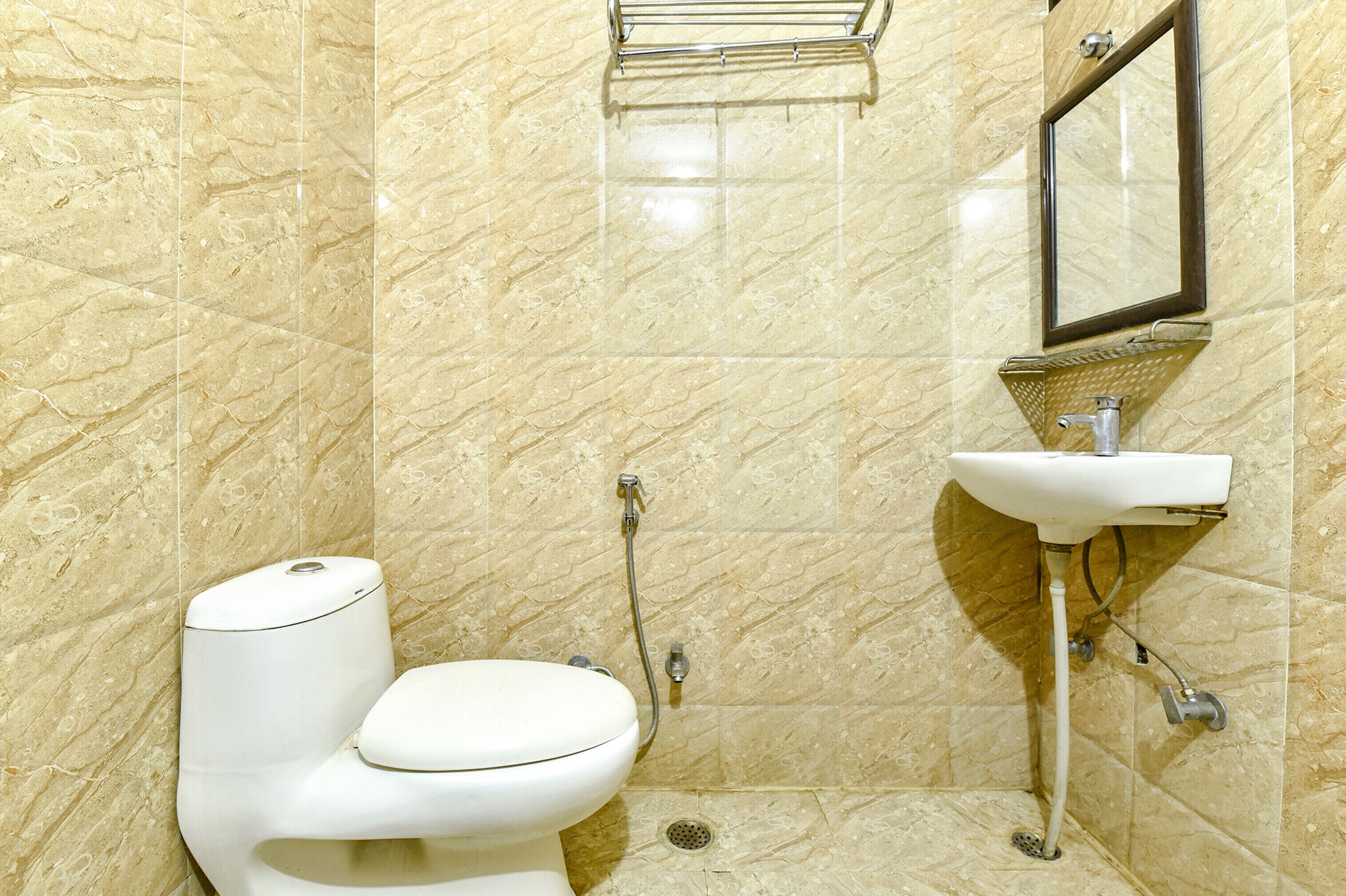 Une salle de bain avec des toilettes, un lavabo et une douche.