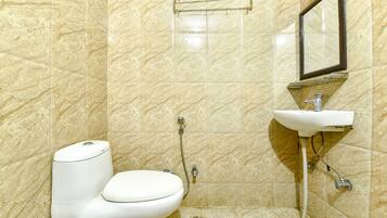 Une salle de bain avec des toilettes, un lavabo et une douche.