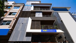 Um hotel moderno com um destaque para a placa '1abHOTELS', várias varandas e uma combinação de estilos de janela.