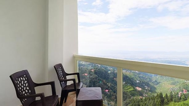 Un balcon avec deux chaises et une petite table, offrant une vue sur un paysage magnifique.