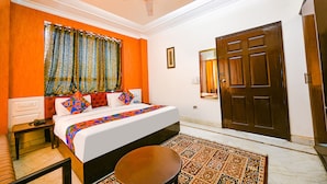 A hotel room with a bed, nightstand, and a large window with curtains. - Fabhotel Mosca (Gurugram)