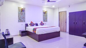A modern bedroom with a bed, nightstands, a desk, and a wardrobe.