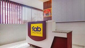 A reception desk with a 'fab hotels' logo, a framed religious painting, and a modern interior design.