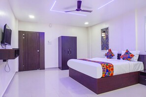 A modern bedroom with a bed, wardrobe, and a television.