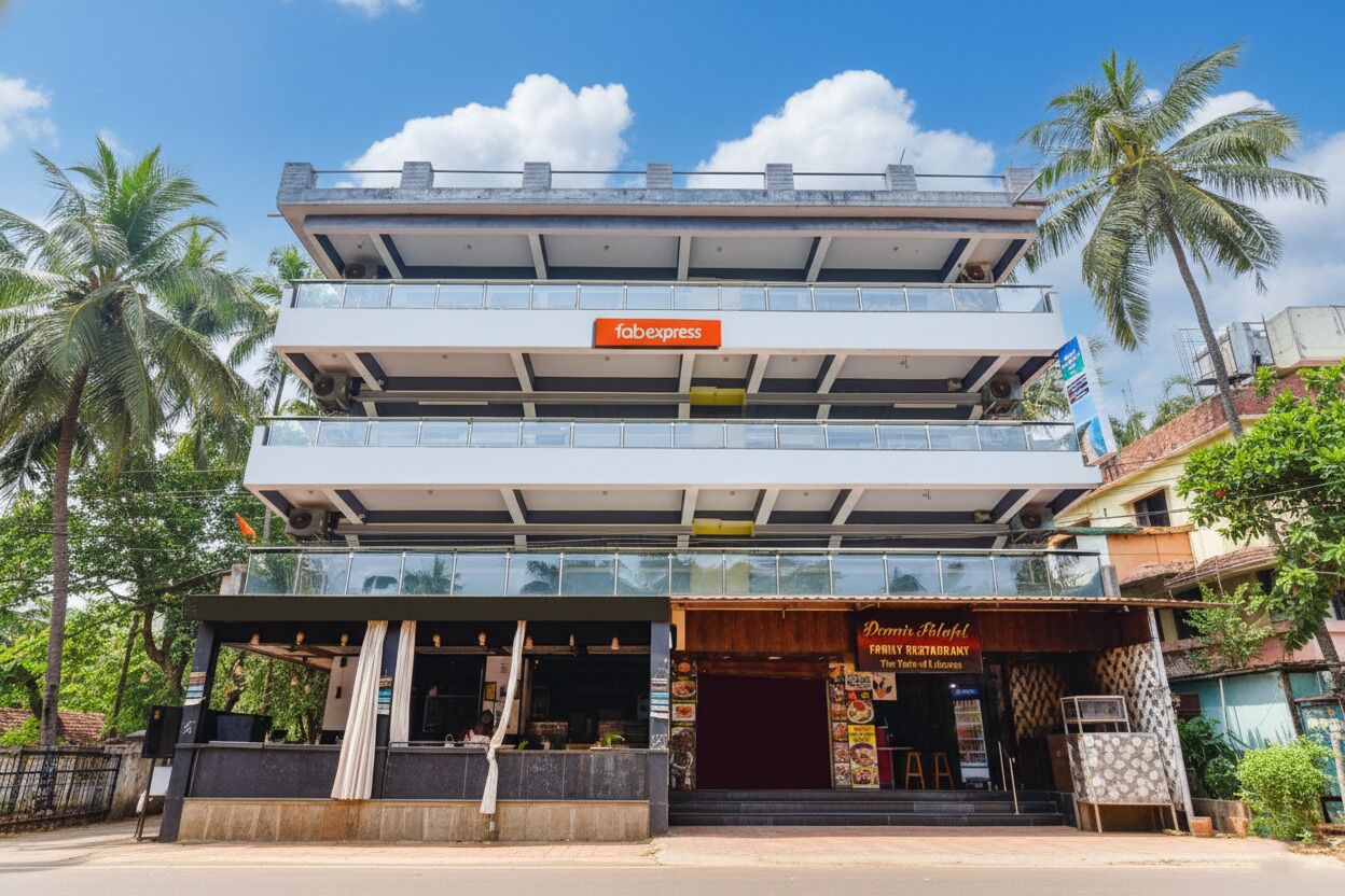 A multi-story building with a 'Fabexpress' sign on the top floor, a restaurant named 'Dinesh Paloh' on the ground floor, and a clear blue sky with palm trees in the background.