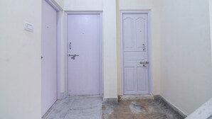 A narrow hallway with two doors, one closed and one open, leading to a room. - Fabexpress Vedika (Kolkata)