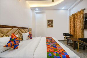 A hotel room with a bed, a desk, and a chair.