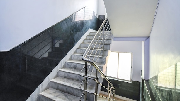 A modern staircase with metal railings and marble steps, leading to a bright interior space. - FabHotel Srideep (Kolkata)
