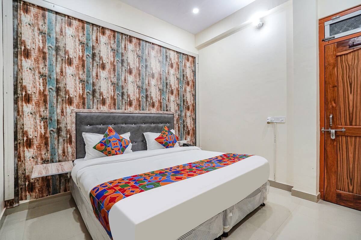 A bedroom with a bed, a wooden headboard, and a wooden door.