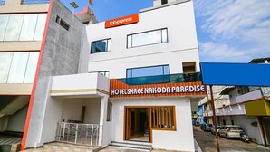 A modern hotel with a sign reading "HOTELSHREE NAKODA PARADISE".