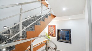 Una escalera moderna con barandales de metal y peldaños de mármol.
