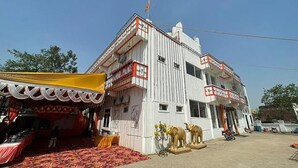 A building with a white exterior, multiple balconies, and a flag on top. - Fabhotel Kalawati Palace (Faizabad)