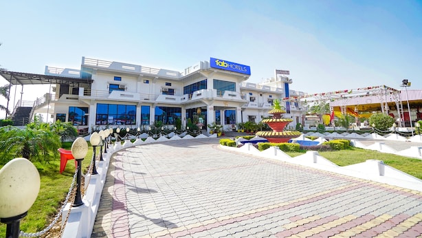 A modern hotel with a prominent 'fab hotels' sign, a landscaped garden, and a clear sky. - FabExpress Savitri Resort (Sohawal)