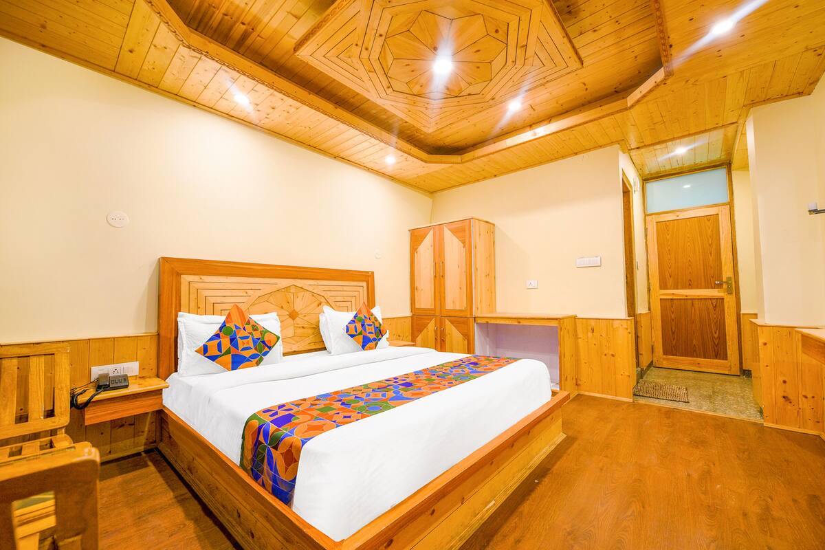 Un dormitorio con paneles de madera, una cama grande, una mesita de noche y un armario.