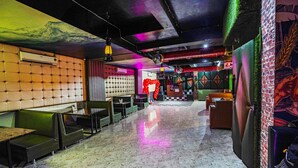 Un restaurante con cabinas, mesas y un escenario con una bola de discoteca.