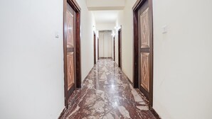 Un pasillo con puertas decoradas y suelo de mármol.