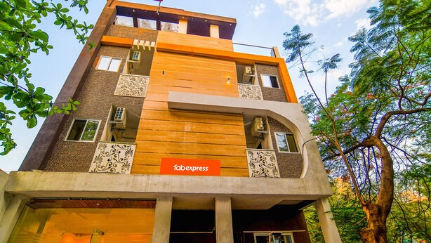 A hotel with a modern design, featuring a prominent 'HOTEL' sign at the top, a 'faexpress' sign on the facade, and a balcony with decorative railings. - Fabexpress Regal (Indore)